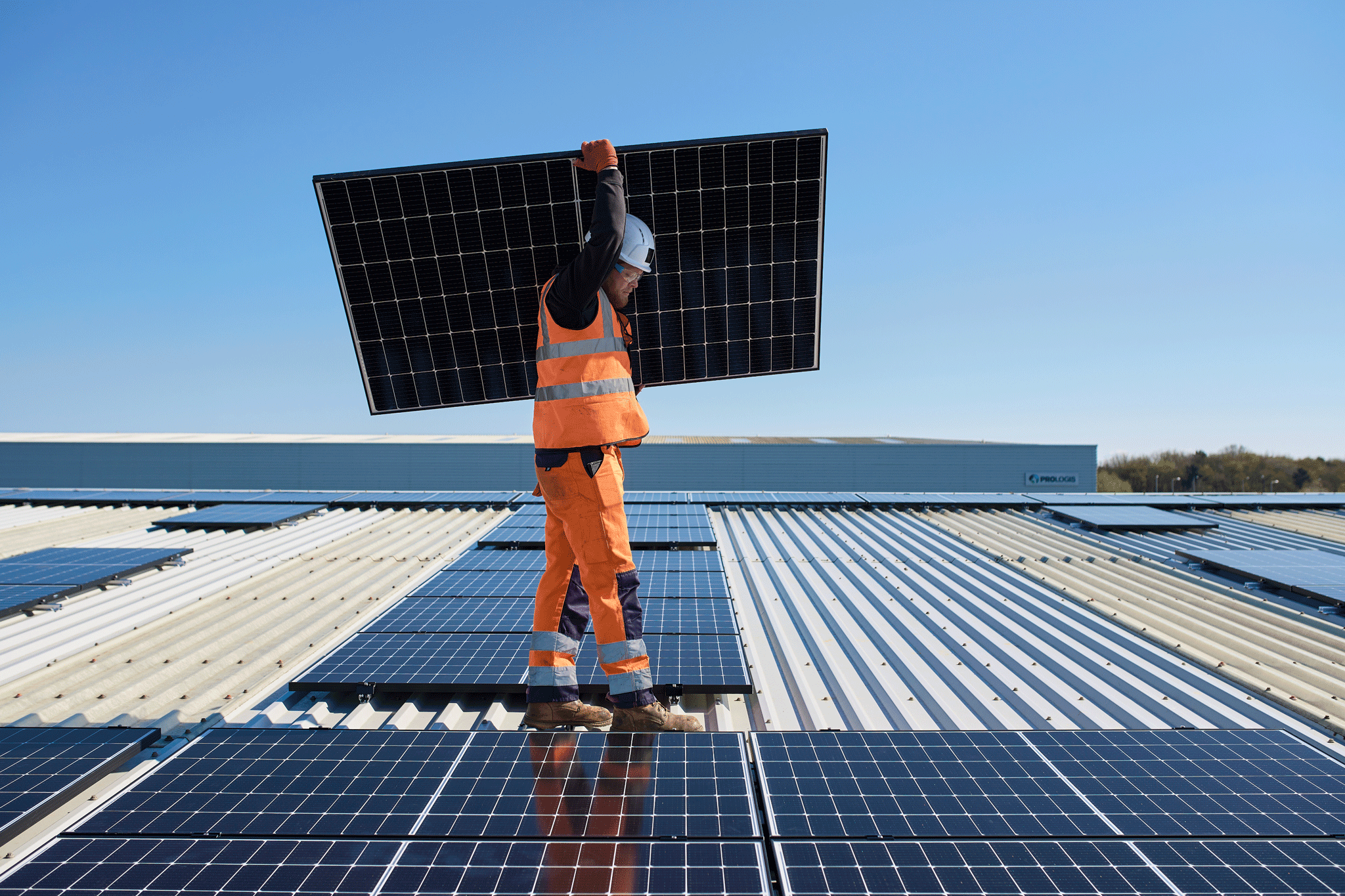 Persona che trasporta un pannello solare su un tetto