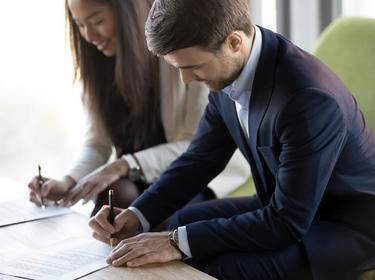 A man and woman signing documents