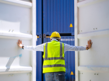 Lavoratore che apre le porte di un container di spedizione